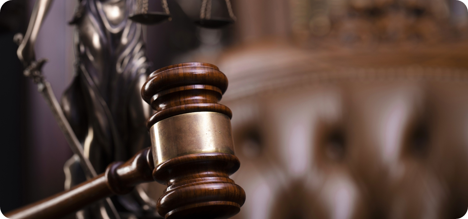 Bild 02 (1)Richterhammer vor einer Figur von Justicia