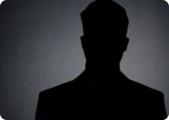 Silhouette einer Person in dunkler Kleidung vor einem dunklen Hintergrund.
